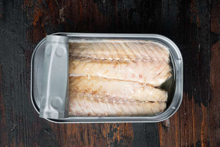 Canned Mackerel Fillets in Tin set, in tin can, on old dark wooden table background, top view flat layの写真素材