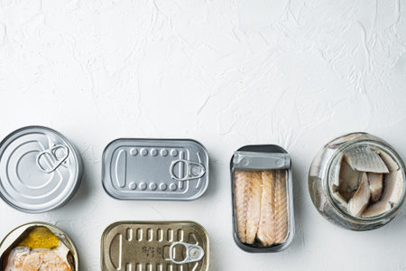 Assortment of cans of canned with different types of fish set, on white background, top view flat...