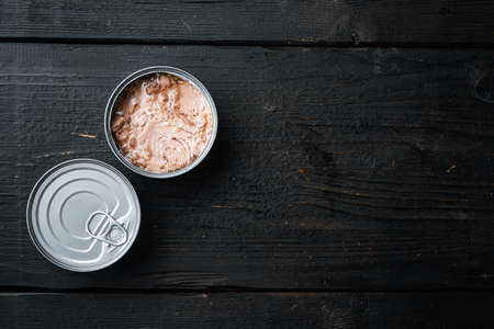 Canned italian tuna set, in tin can, on black wooden table background, top view flat lay, with copyspace and space for textの写真素材
