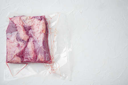 Cryovac packed meat Beef brisket in vacuum set, on white stone background, top view flat lay, with copyspace and space for textの写真素材