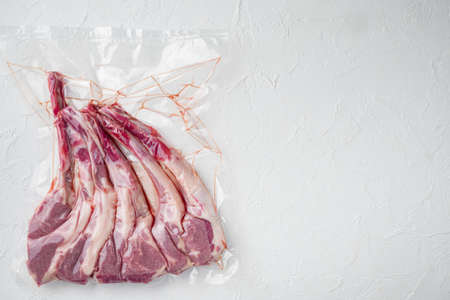 Lamb ribs for sous vide cooking in plastic vacuum package set, on white stone background, top view flat lay, with copyspace and space for textの写真素材
