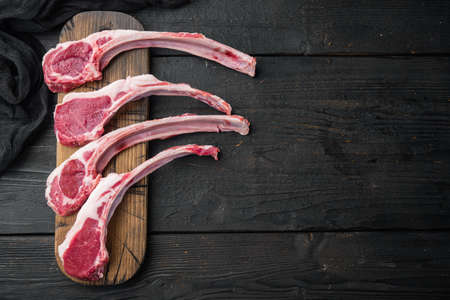 Fresh chopped calf Racks of lamb ready for cooking set, on black wooden table background, top view flat lay, with copyspace and space for textの写真素材
