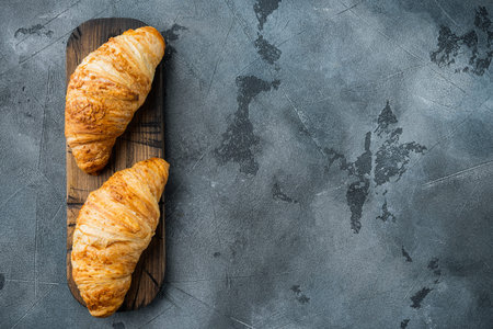 Crispy fresh croissants set, on gray stone background, top view flat lay, with copy space for textの写真素材
