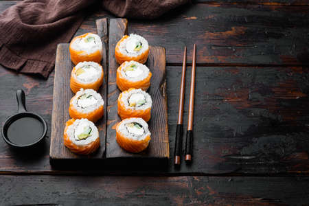 Sushi roll, Philadelphia with salmon, smoked eel, avocado, cream cheese set, on old dark wooden table background, with copyspace and space for textの写真素材