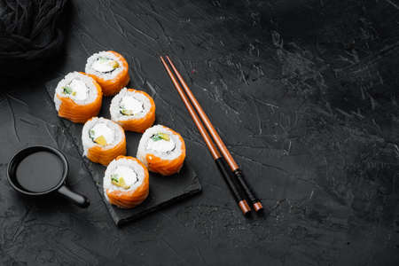 Philadelphia roll sushi with salmon, prawn, avocado, cream cheese set, on black stone background, with copyspace and space for textの写真素材