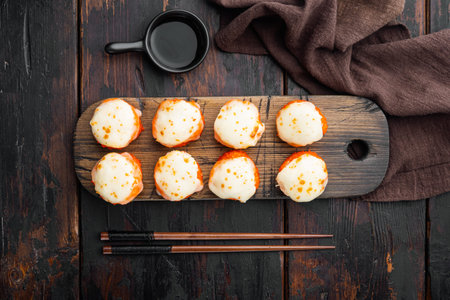 Baked sushi roll with shrimp and masago caviar cap. Traditional sushi restaurant dish set, on old...
