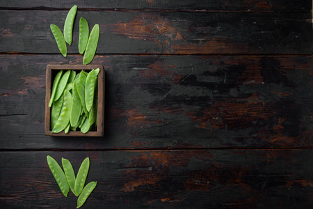Healthy snap peas set, in wooden box, on old dark wooden table background, top view flat lay, with...