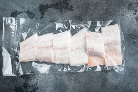 Haddock fish skinless in vacuum package, on gray background, top view