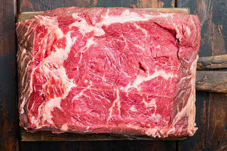 Sirloin steak, uncooked beef meat cut, on dark wooden background, top viewの写真素材