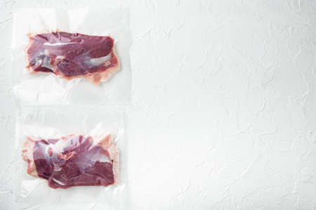 Raw duck breast in seal bag for sous vide cooking set, on white stone background, top view flat lay, with copyspace and space for textの写真素材