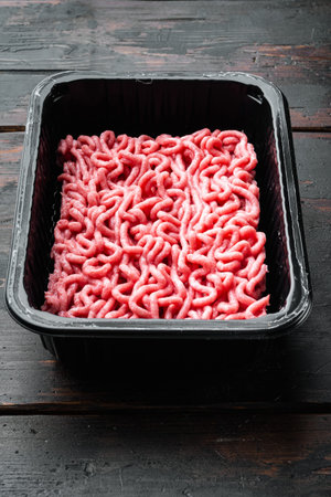 Minced meat in packaging set, on old dark wooden table background