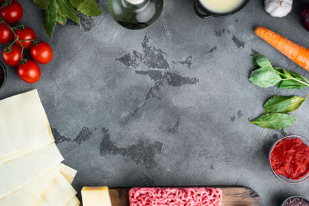 Empty space clean Frame set The concept of cooking lasagna. Italian Ingredients, lasagna sheets meat herbs tomatoes, bechamel sauce, on gray stone background, top view, flat lay, with copy space for textの写真素材