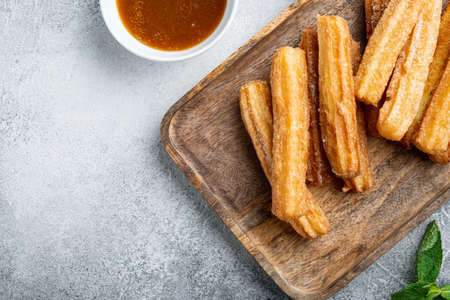 Churros sprinkled with powdered sugar set, on gray background, top view flat lay with space for text, copyspaceの写真素材