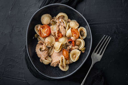 Pasta with vegetables and tuna in bowl, on black background, top viewの写真素材