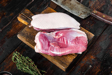 Fresh duck meat for food, Raw duck breast set, on wooden cutting board with old butcher cleaver knife, on old dark wooden table backgroundの写真素材