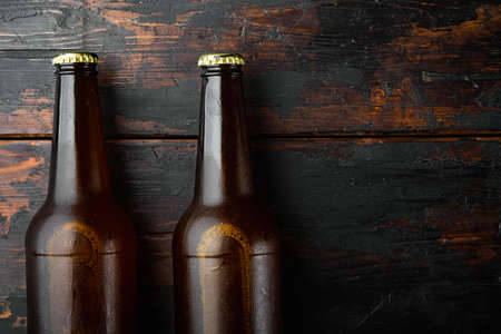 Fresh beer in glass bottles set, on old dark wooden table, top view flat lay, with copy space for textの写真素材