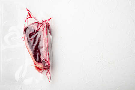 Club steak in Vacuum pack set, on white stone surface, top view flat lay, with copy space for textの写真素材