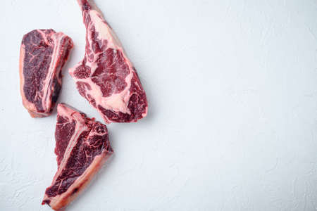 Various cuts of meat dry aged beef set, tomahawk, t bone or porterhouse and club steak, on white stone background, top view flat lay, with copy space for textの写真素材