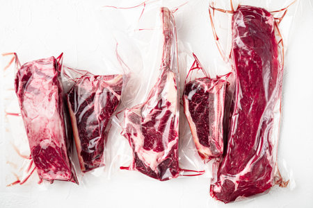 Beef steak vacuum set, tomahawk, t bone, club steak, rib eye and tenderloin cuts, on white stone...