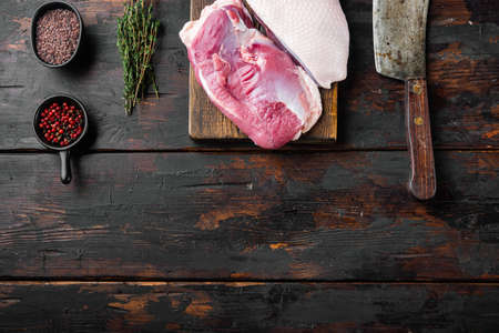 Fillet of duck uncooked, raw meat set, on wooden cutting board with old butcher cleaver knife, on old dark wooden table background, top view flat lay, with copyspace and space for textの写真素材