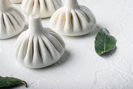 Stuffed dumplings, manti of dough and minced set, on white stone surface, with copy space for text