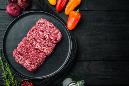 Fresh raw minced beef, ground meat, on black wooden table background, top view flat lay with copy space for textの写真素材