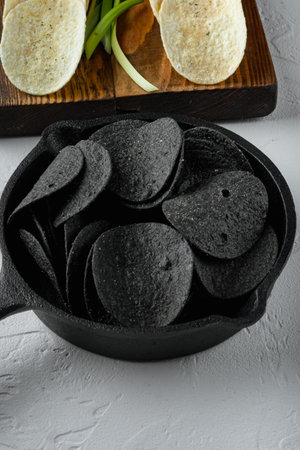 Cheese and chive potato crisp snack set, with dipping sauces tomato dip sour cream, on white stone surfaceの写真素材