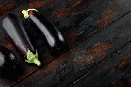 Raw ripe eggplants from the garden farm set, on old dark wooden table background, with copy space for textの写真素材