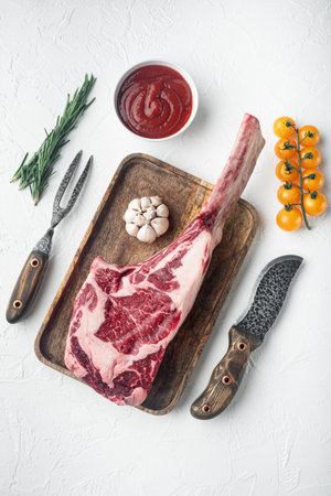 Tomahawk beef steak raw set, with seasoning and herbs, on white stone background, top view flat lay
