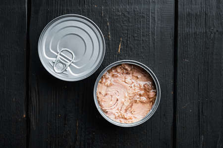Canned Wild Yellowfin Tuna set, in tin can, on black wooden table background, top view flat lay, with copyspace and space for textの写真素材