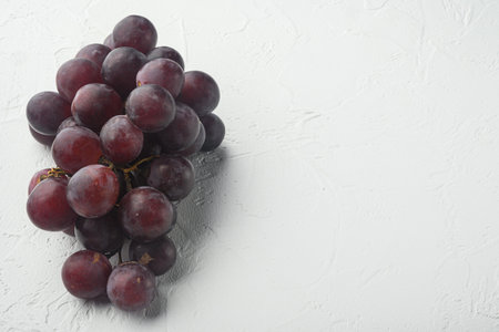 Finest natural home bunch of grapes set, dark red fruits, on white stone background, with copy space...