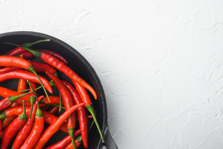 Fresh Spur pepper set, in frying cast iron pan, on white stone background, top view flat lay, with...