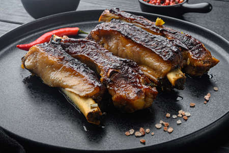 Barbecue pork spare ribs with fruit relish set, on plate, on black wooden table backgroundの写真素材