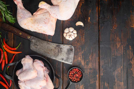 Fresh chicken meat cuts Farm poultry meat set, and old butcher cleaver knife, with seasoning and herbs rosemary and thyme, on old dark wooden table background, top view flat lay, with copy space for textの写真素材