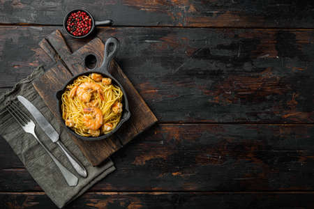Pesto prawn pasta served, in cast iron frying pan, on old dark wooden table, top view flat lay, with copy space for textの写真素材