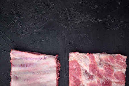 Organic pork ribs set, on black stone background, top view flat lay, with copy space for textの写真素材