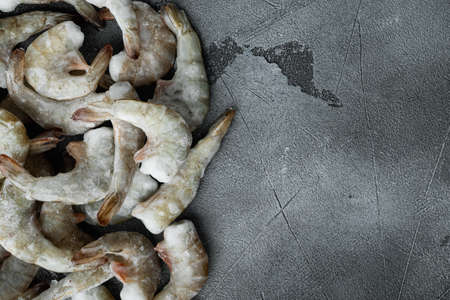 Frozen raw uncooked tiger prawns, shrimps set, on gray stone background, top view flat lay, with copy space for textの写真素材