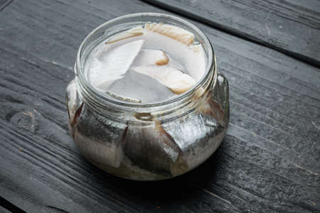 Icelandic herring set, in glass jar, on black wooden table backgroundの写真素材