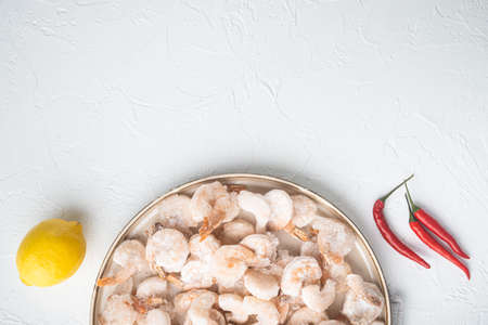 Frozen peeled boiled prawns set, on plate, on white background, top view flat lay, with copy space for textの写真素材