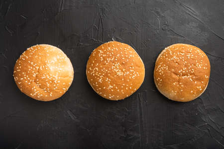 Burger buns, homemade sesame buns patty Brioche for sandwich set, on black stone background, top view flat lay, with copy space for textの写真素材