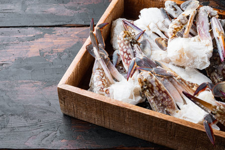 Frozen raw blue swimming crab meat set, in wooden box, on dark wooden background, with copyspace and space for textの写真素材