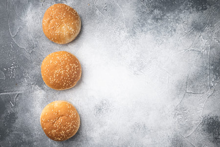 Sandwich bun with sesame seeds set, on gray background, top view flat lay, with copy space for text