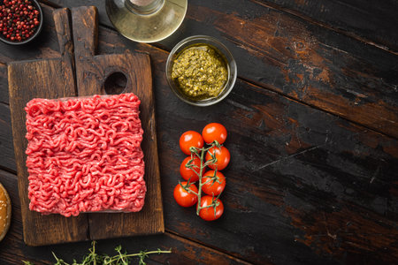 Homemade minced meat in a black bowl with ingredients. Fresh Raw mince for cooking meatballs set, on...