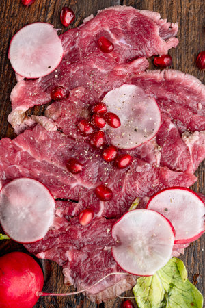 Marbled beef carpaccio set, with Radish and garnet, on wooden serving board, top view flat layの写真素材