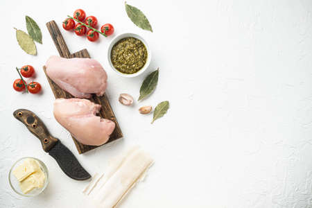 Chicken breast stuffed with ingredients and filo set, on white stone background, top view flat lay, with copy space for textの写真素材