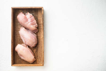 Chicken breast fillets set, in wooden box, on white stone background, top view flat lay, with copy space for textの写真素材