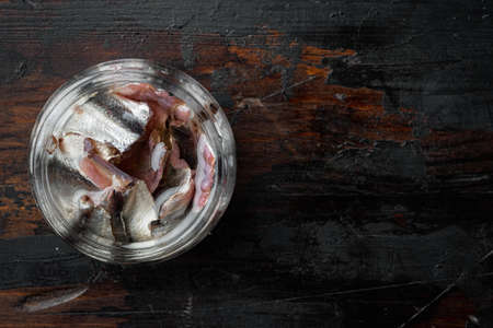 Canned Anchovies set, in glass jar, on old dark wooden table background, top view flat lay, with copyspace and space for textの写真素材