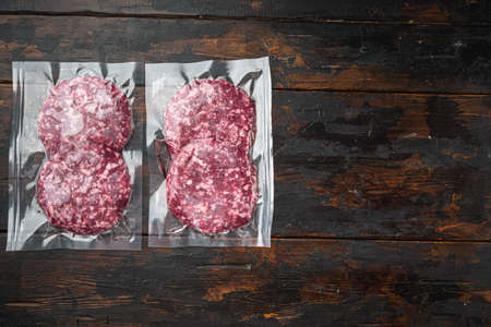 Burger meat vacuum sealed ready for sous vide cooking set, on old dark wooden table background, top view flat lay, with copy space for textの写真素材