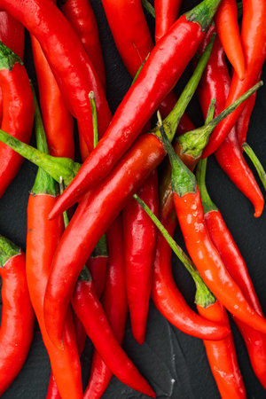 Long fed pepper set, on black stone background, top view flat lay