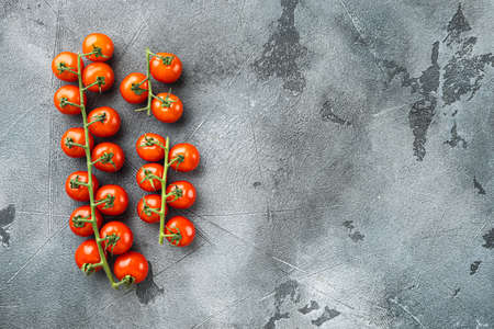 Cherry tomatoes on branch set, on gray stone background, top view flat lay, with copy space for textの写真素材